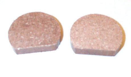 Close-up of Organic Brake Pads for Arctic Cat Snowmobiles (1974-1979) showing two round, brown pads designed for reliable performance in extreme temperatures and resistance to shock and vibration.