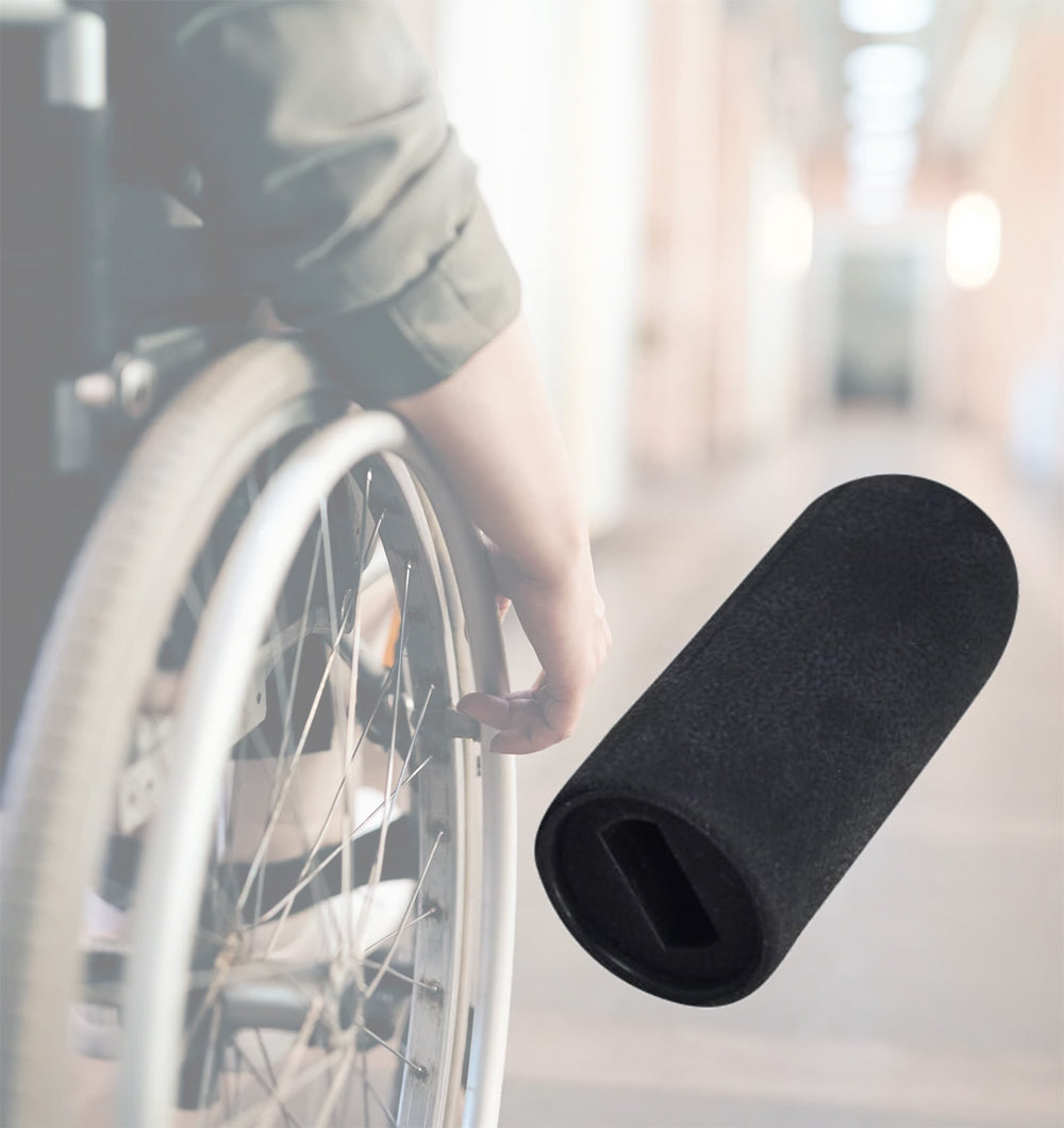 Black Rubber Tips for 1/2 Flat Invacare Style Wheelchair Wheel Locks (Set of 2) held by a person in a wheelchair, showing the small black rubber lever knobs designed for wheelchair wheel locks.