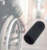 Black Rubber Tips for 1/2 Flat Invacare Style Wheelchair Wheel Locks (Set of 2) held by a person in a wheelchair, showing the small black rubber lever knobs designed for wheelchair wheel locks.