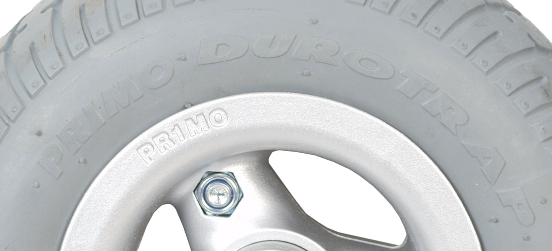 9 Flat-Free Caster Wheel for the Quantum Rival, showing a close-up of the gray tire mounted on a silver rim with bearings and spacer installed.