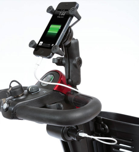 A cell phone mounted on a handlebar with the Pride XLR USB Charger connected, illustrating its use on mobility scooters and power chairs to keep devices charged.