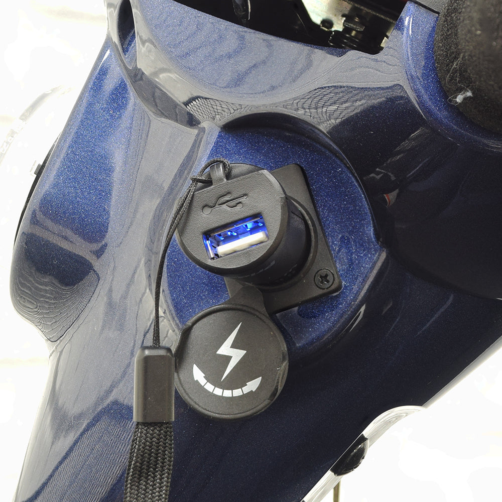 Pride XLR USB Charger plugged into a mobility scooter’s XLR port, featuring a compact design with a visible blue light indicator.