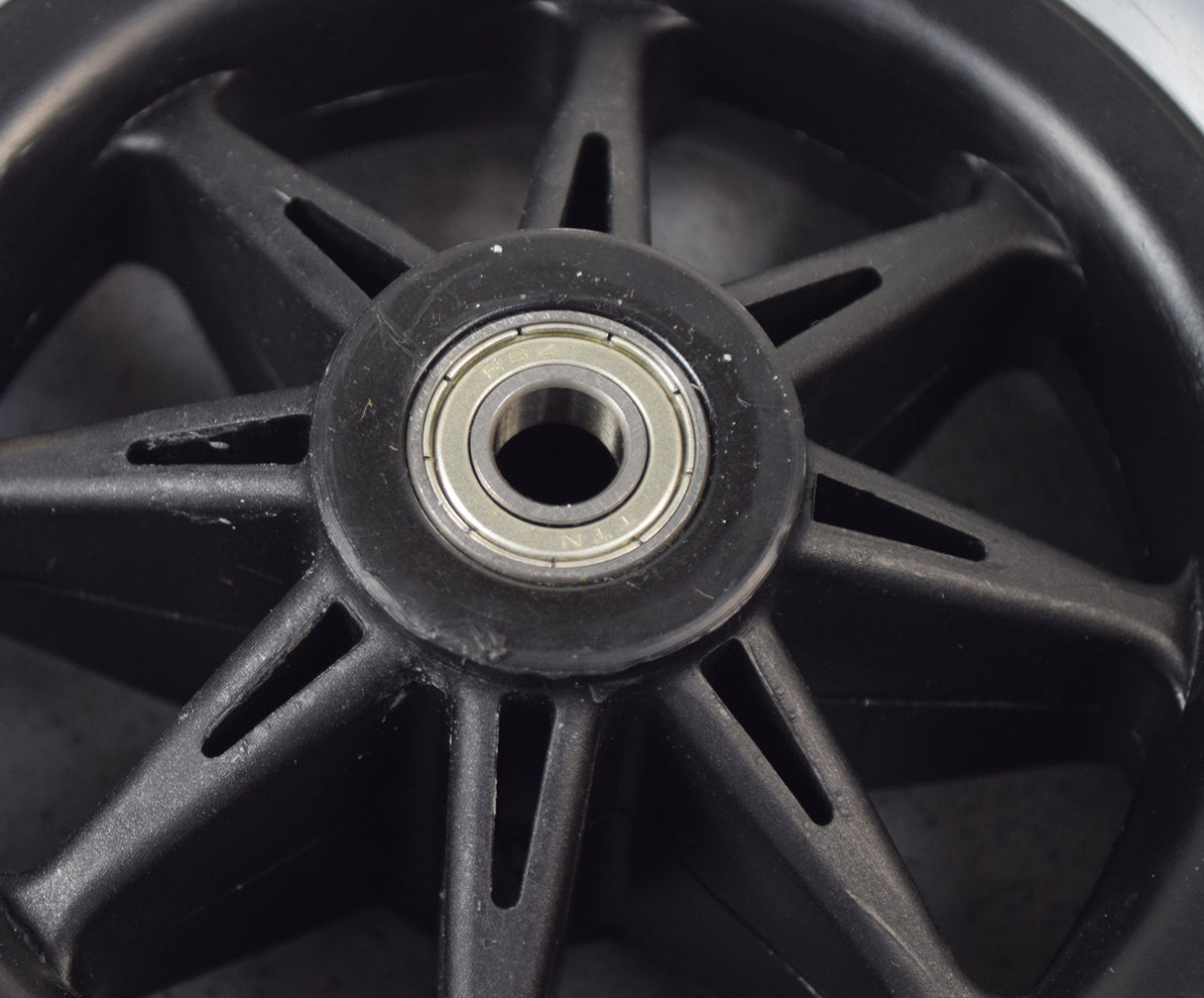 Front Anti-tip Wheel Assembly for Jazzy & Quantum Power Chairs (WHLASMB1334) showcasing a close-up of a black wheel with a metal center, featuring a 200 mm x 50 mm solid polyurethane tire and R6Z bearings.