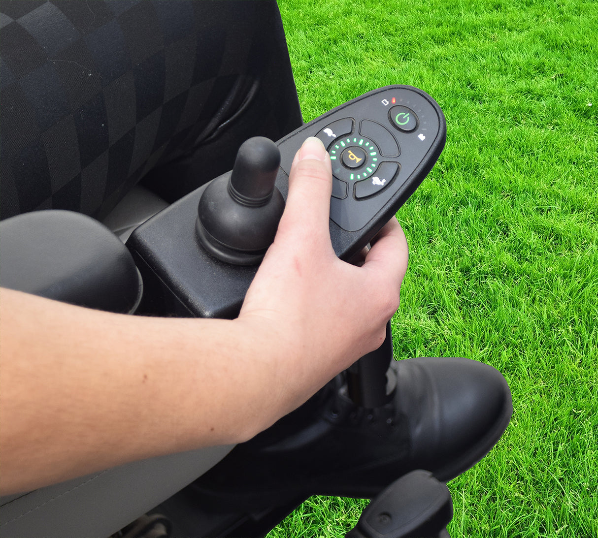 Keypad for the 4 Key Dynamic Shark DK-REMD01 and DK-REMD02 (MK5 SPJ+) Joystick, shown with a person's hand holding the joystick remote, highlighting the keypad's installation on a wheelchair.