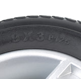 Close-up of a 9x3 Black Flat-Free Rear Wheel Assembly with a Silver Tri-Spoke Rim for Go-Go Elite Traveller Plus, Elite Traveller Plus HD, & Sport mobility scooters, highlighting the tire tread and rim details.