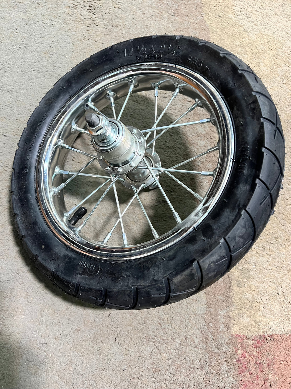 Rear Wheel Assembly with Wire Spoke Rim for the Razor Pocket Mod (Versions 31+) (Blemished), featuring a 12-1/2 x 2-1/4 tire, tube, band brake, rim, and wheel bearings, shown in a close-up image.