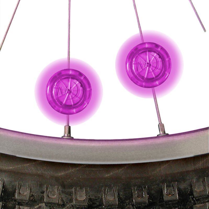 Close-up of Pink Mini LED Spoke Lights for Bikes & Scooters, showing bright LED illumination on bicycle tire.