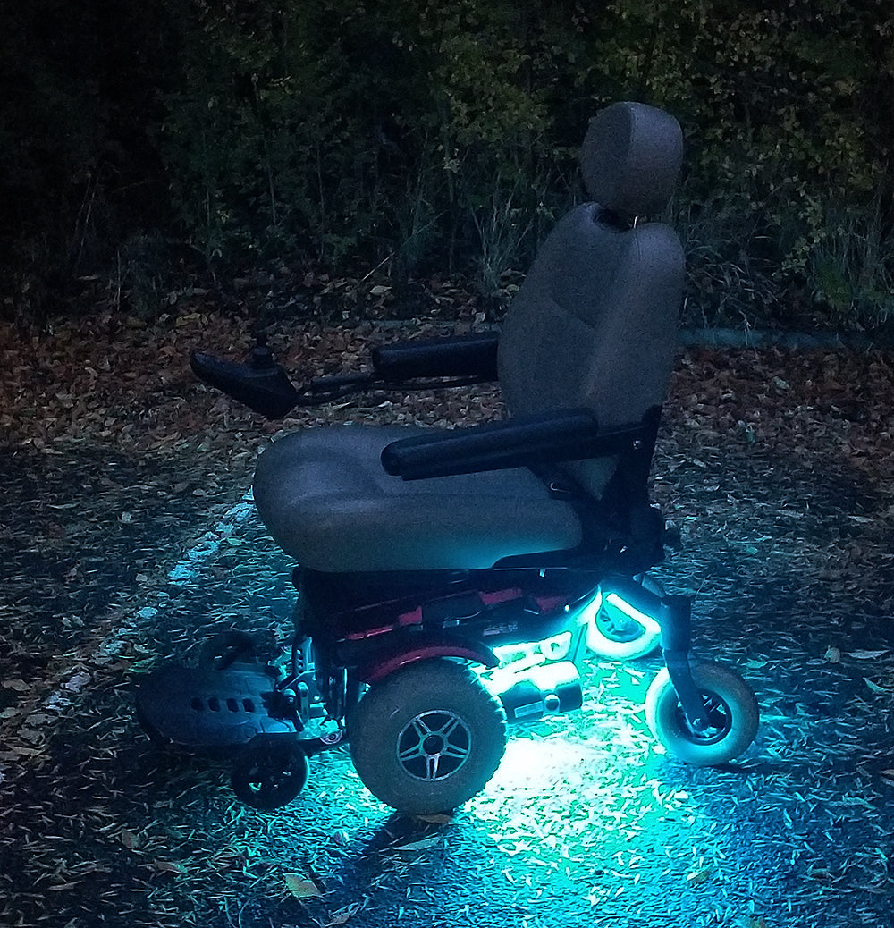 Multi-Color LED Light Kit for Jazzy Power Chairs featuring a wheelchair with glowing wheels illuminated by vibrant light strips, enhancing both safety and style.