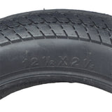 12-1/2x2-1/4 Scooter Tire with K912 Tread, featuring a close-up view of the detailed v-shaped sipes on the black tire's surface for enhanced street performance.