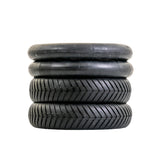 12-1/2x3.0 Tire with V-Groove Street Tread for the Schwinn S500 Scooter, featuring a stack of black tires with shallow grooves, ideal for enhanced grip on wet, hard-paved surfaces.