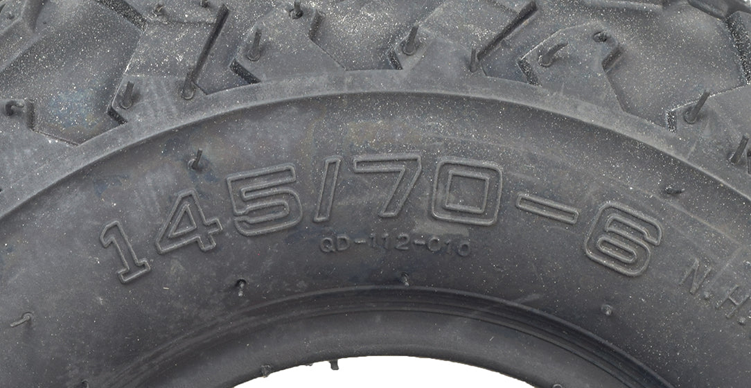 Close-up of a 145/70-6 tire with aggressive V-tread for Baja Blitz, Dirt Bug, Doodle Bug, and Racer mini bikes, showcasing deep treads ideal for muddy and loose surface conditions.