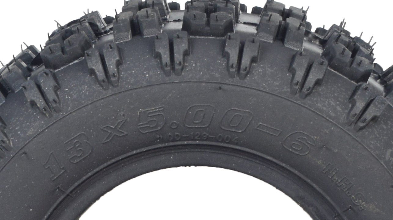 Close-up of the 13x5.00-6 MotoTec MT-ATV Mini Quad tire, showcasing its aggressive tread pattern designed for enhanced grip on loose surfaces.