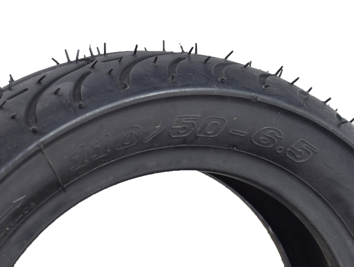 Close-up of the 110/50-6.5 tire for the MotoTec MT-MB 24 Volt Electric Mini Bike, showing its shallow grooved tread for excellent traction.