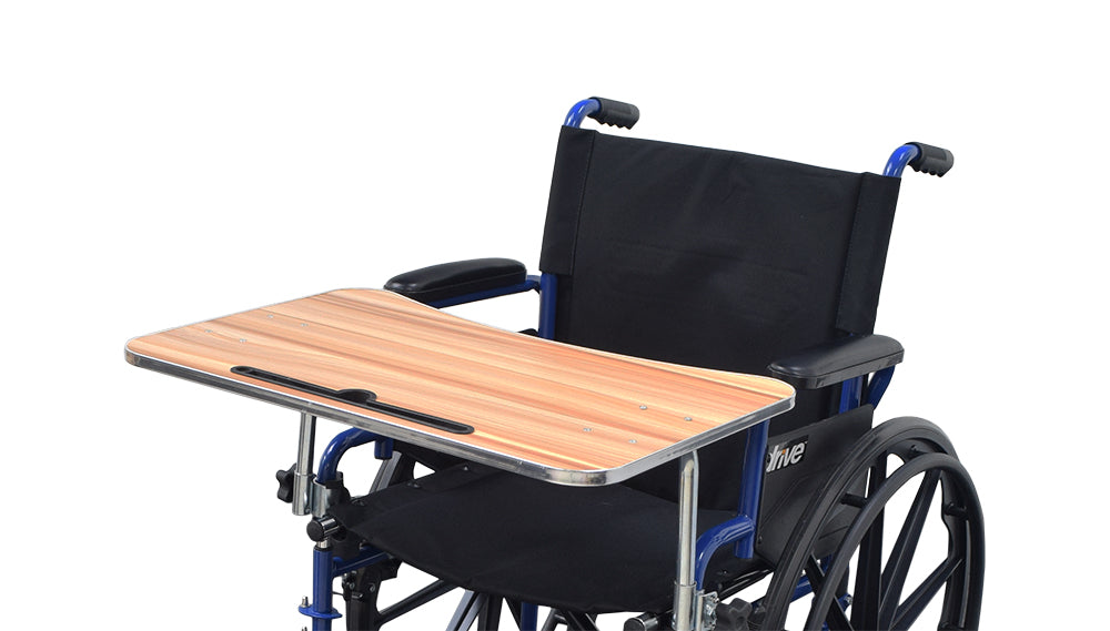 Wood Veneer Tray Table for Wheelchairs: A functional tray table with a woodgrain laminate surface, mounted on a wheelchair with steel supports and adjustment knobs. Suitable for writing, devices, and includes a pencil slot.