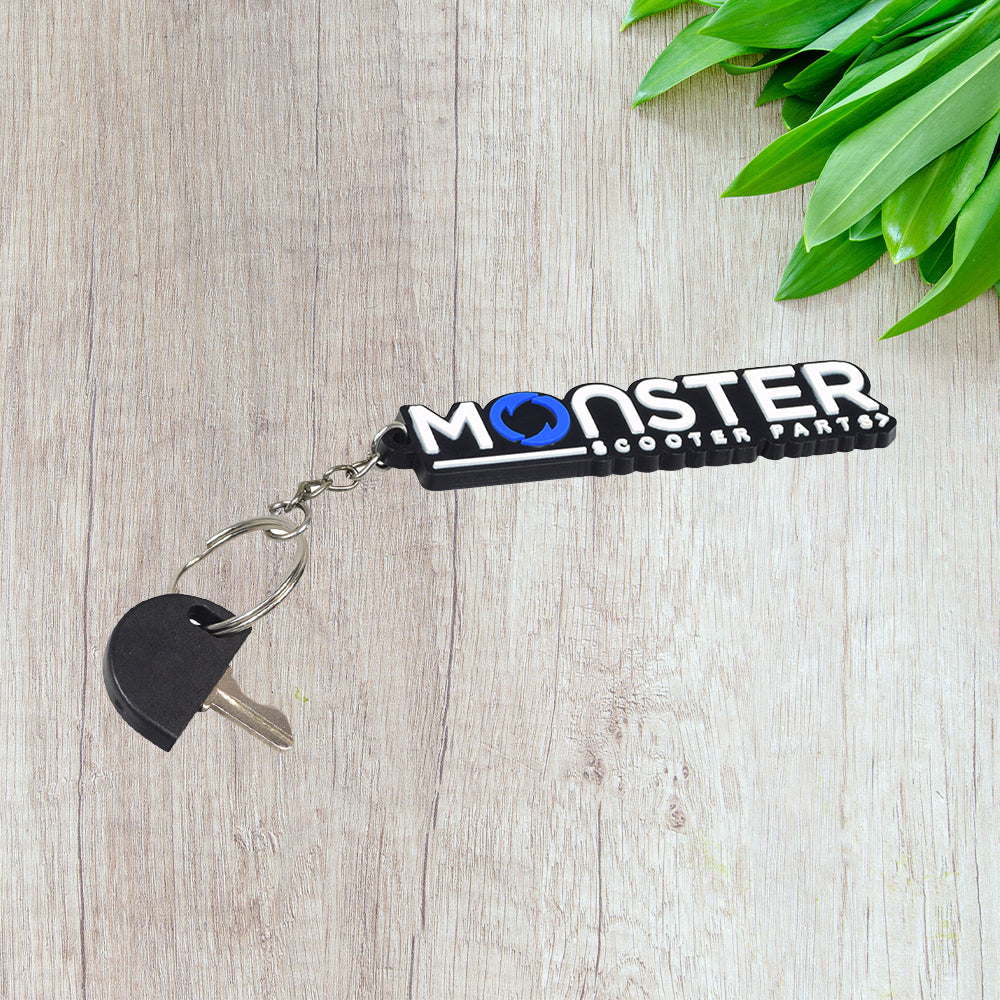 Key chain featuring a Standard Key for Go-Go and Pride Mobility Scooters, with a half circle black plastic head and keyring, displayed on a wooden surface.