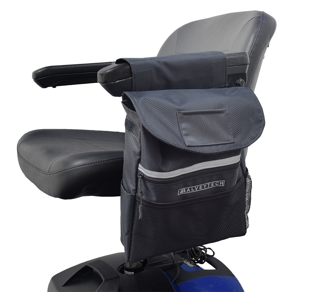 Saddle Bag for Mobility Scooters, Power Chairs, & Wheelchairs mounted on a chair armrest, featuring a single pocket with a Velcro closure and extra zippered pouches.