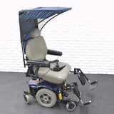 Weatherbreaker Canopy for Scooters & Power Chairs featuring a protective canopy over a wheelchair, visible sturdy wheels, and a foot pedal for enhanced mobility in various weather conditions.