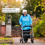 Super Deluxe Universal Walker & Rollator Bag attached to a woman's walker outdoors, showing its multiple pockets and bungee cord net for storage.