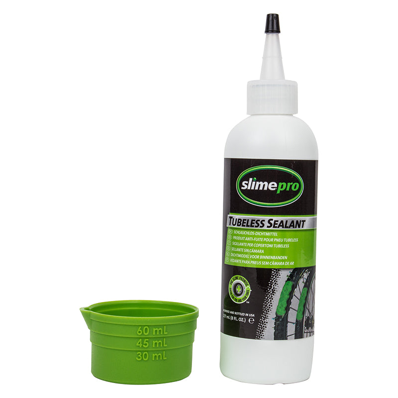 Slimepro Tubeless Sealant - 8 oz Bottle, shown with a green measuring cap, instantly seals punctures up to 1/8, protects wheels from corrosion, and features a tropical scent.