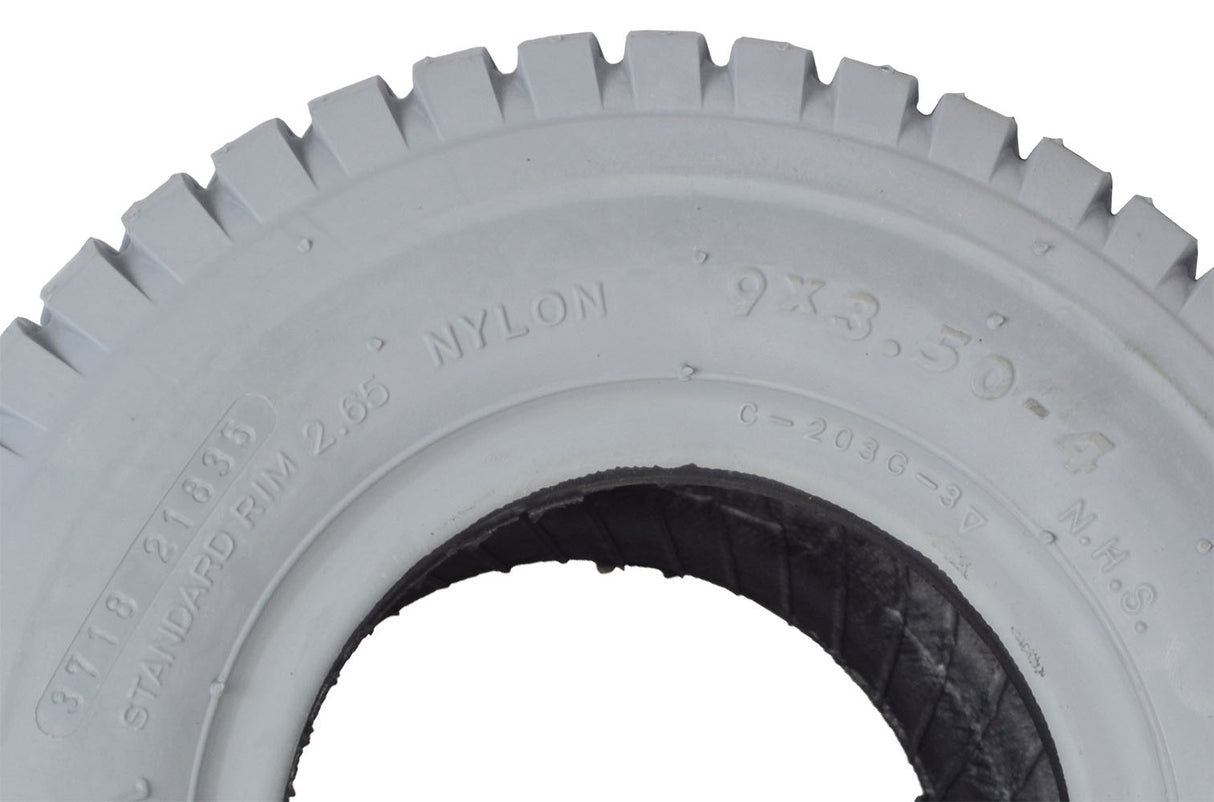 9x3.50-4 Pneumatic Mobility Tire with C203 Grande Knobby Tread, shown in close-up with distinct black treads and non-marking gray rubber, suitable for wheelchairs and scooters.