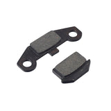 Front Brake Pad Set for Coleman AT125-EX & AT125-UT ATVs (Left & Right) shown in a close-up view, highlighting the detailed surface texture and the asymmetric design of the brake pads.