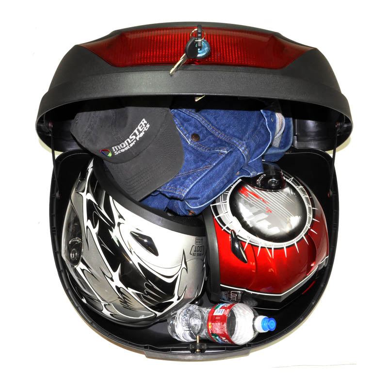 Universal Top Case Scooter Trunk shown in an open state, containing a red and black motorcycle helmet and blue jeans, highlighting its storage capacity and practical use for scooter riders.