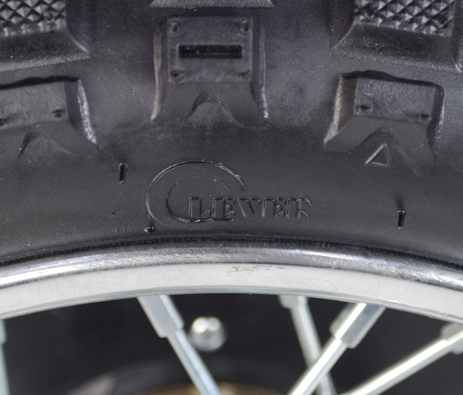 Close-up of the Rear Wheel Assembly for Razor MX500 and MX650, showing the tire with treads, rim, and axle. The image highlights the tire's detailed surface and the assembly components.