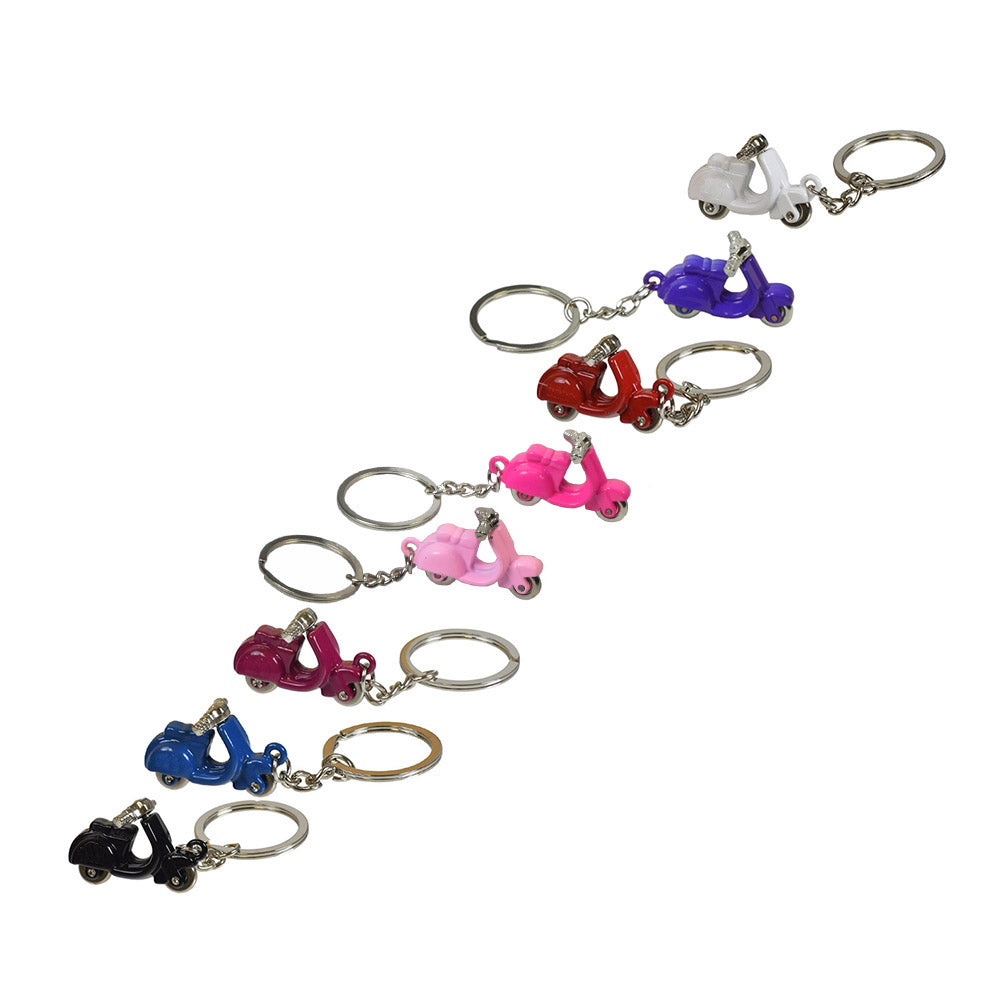 Scooter Keychain: A row of variously colored keychains featuring miniature toy scooters. Ideal for scooter enthusiasts, these keychains are compact and practical, perfect for everyday use or as thoughtful gifts.