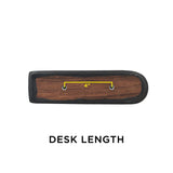 Black Vinyl Co-Molded Armrest Pad for Pride Scooters shown on a wooden desk with a yellow line, featuring a square end and a rounded end, designed for scooter armrests.