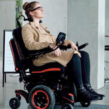 Joystick Rubber Boot for PG Drives Joystick Controllers (VSI, VR2, GC, and Remote Plus) shown on a power chair joystick, with a woman sitting in a wheelchair visible in the background.