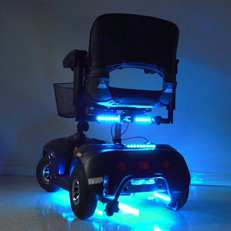 Multi-Color LED Light Kit for Pride Mobility Scooters featuring a wheelchair with vibrant blue lights, showcasing the installation and glowing effect of the LED strips for enhanced visibility and style.