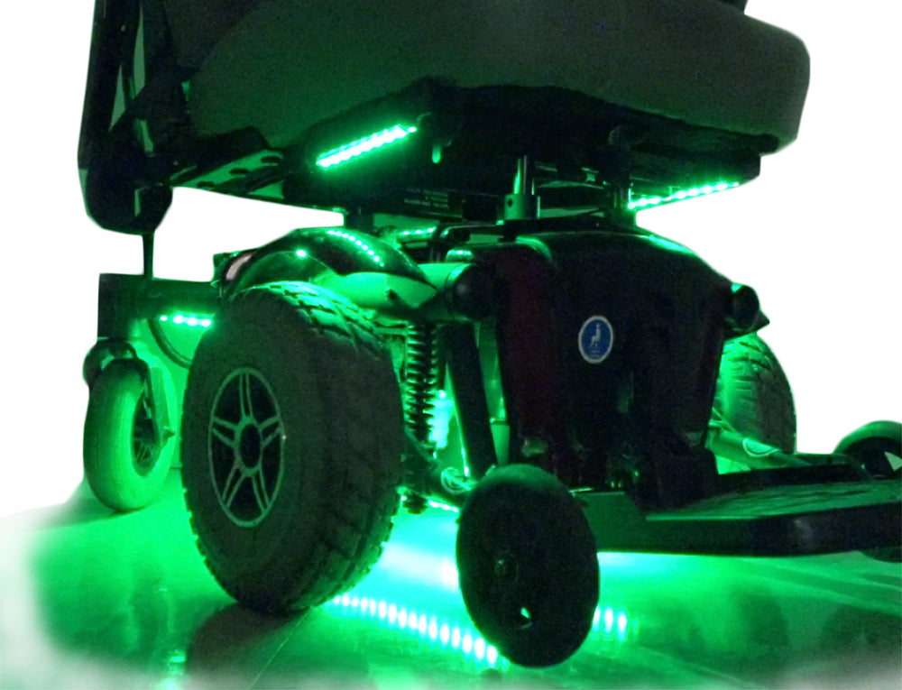 Close-up of a wheel on a Jazzy Power Chair, highlighting the Multi-Color LED Light Kit attachment for enhanced visibility and style.