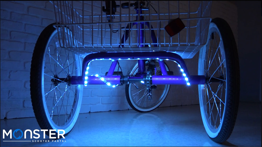 LED Bicycle Strip Light, USB Battery Bank, & Holder Kit on a bike with blue LED lights illuminating the wheels and frame, enhancing night-time visibility with a vibrant, psychedelic light display.