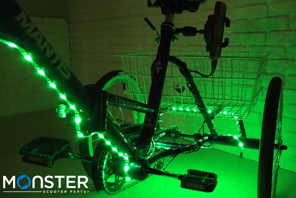 LED Bicycle Strip Light, USB Battery Bank, & Holder Kit displayed on a bicycle with green lights illuminating the wheels and frame, enhancing visibility and creating a vibrant, eye-catching night-time effect.